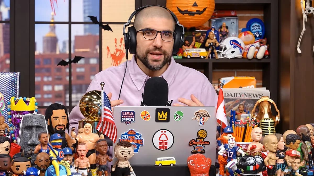 Ariel Helwani habla frente al micrófono en su estudio, con auriculares y una computadora rodeada de figuras deportivas.